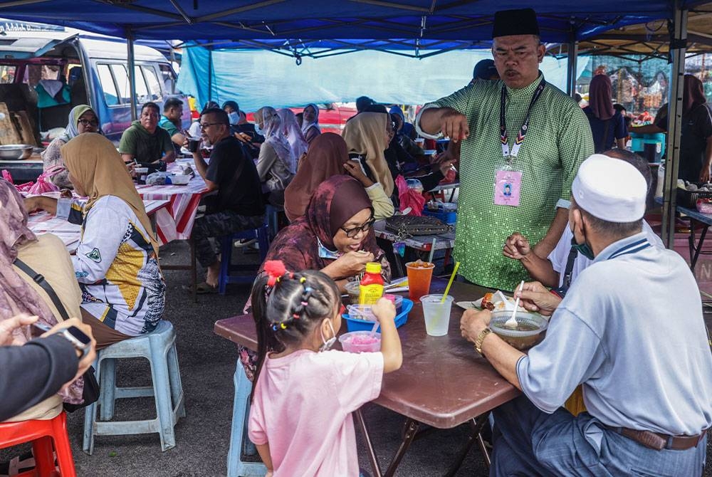 Mohd Johari menyantuni masyarakat Rompin ketika berkempen sempena PRU15 DUN Tioman di Pasar Minggu Kuala Rompin pada Ahad. - Foto Bernama