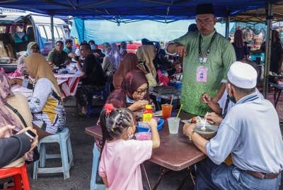 Mohd Johari menyantuni masyarakat Rompin ketika berkempen sempena PRU15 DUN Tioman di Pasar Minggu Kuala Rompin pada Ahad. - Foto Bernama