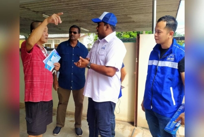 Sivaraj (dua dari kanan) menemui pengundi ketika menjalankan kempen dari rumah ke rumah di Kampung Padang pada Ahad.