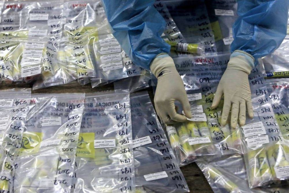 Petugas Kementerian Kesihatan (KKM) melakukan proses penandaan sampel ujian saringan Covid-19. - Foto fail Bernama