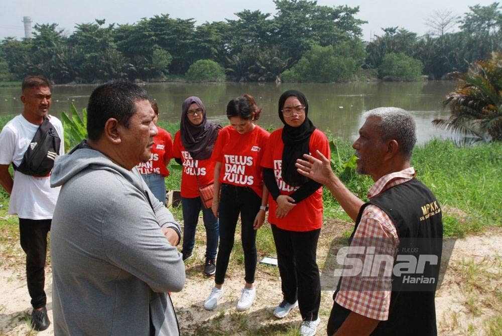 Hashim (kanan) memberi penerangan ketika membuat tinjauan di tebing Sungai Klang bersama Nik Justin (kiri).