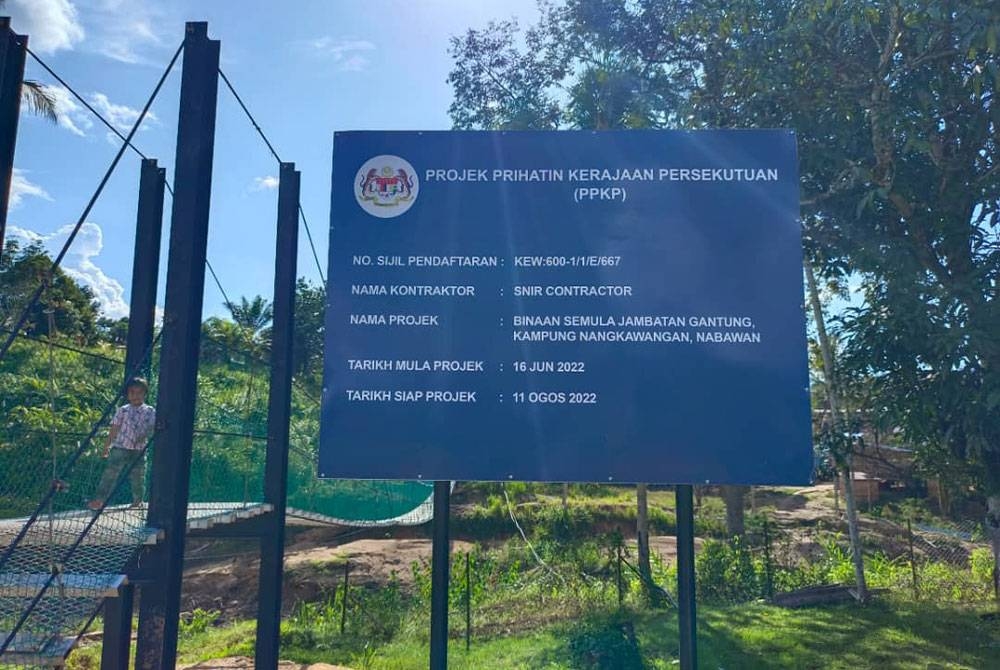 Papan tanda projek yang memaparkan tarikh mula dan siap jambatan gantung di Kampung Nangkawangan.