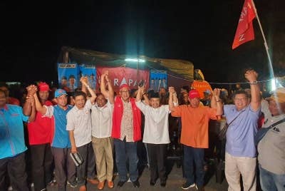 Mohamad (dua dari kanan) bersama pimpinan PH dan BN bergambar bersama selepas berkempen di Taman Desa Aman, Padang Meiha pada Jumaat.