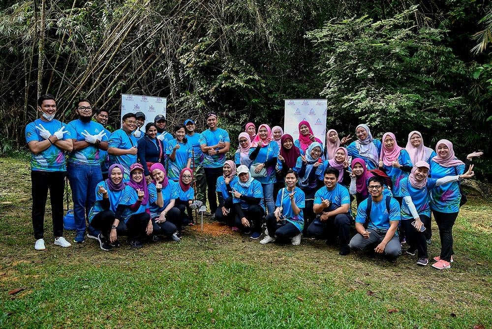 Ketua Pegawai Eksekutif Kumpulan Avisena, Elina Nadia Omar bergambar bersama warga-warga Avisena selepas melakukan kerja-kerja penanaman pokok sempena Program Penghijauan Malaysia anjuran Avisena Healthcare, semalam.