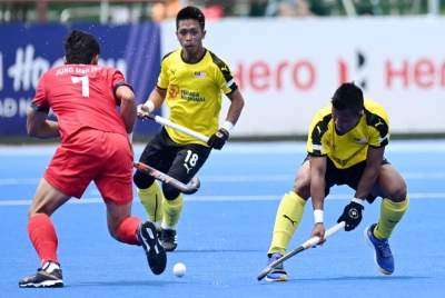 Pemain Korea Selatan, Manjae Jung (merah), mengatasi Zul Pidaus Mizun emasa aksi penentuan tempat ketiga keempat Piala Negara-Negara FIH 2022 di Afrika Selatan pada Ahad. FOTO: WORLDSPORTPICS