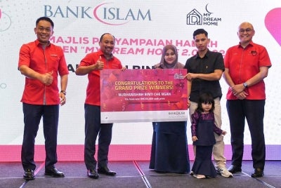 Nurhanishah yang ditemani suami dan anaknya menerima replika hadiah tunai RM250,000 daripada Mizan (dua dari kiri).