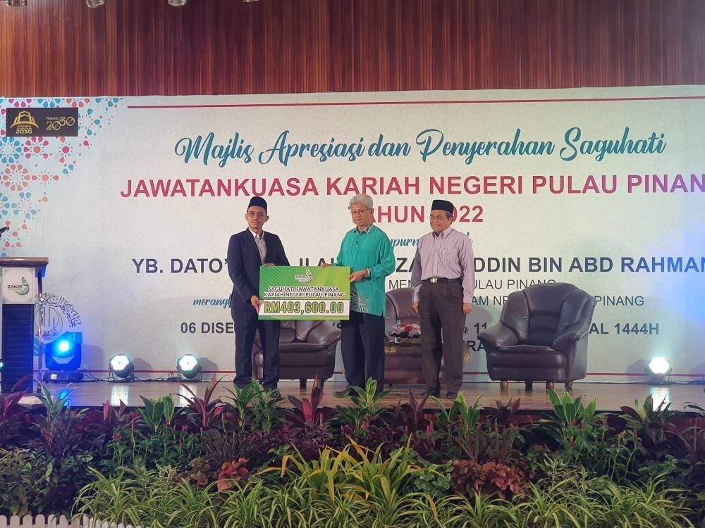 Mohamad Kairi (kiri) menyerahkan replika cek Skim Saguhati Jawatankuasa Kariah kepada Ahmad Zakiyuddin pada majlis yang diadakan di Seberang Jaya. 