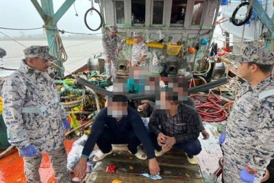 Khairulanuar (kiri) melihat sebahagian kru nelayan asing Vietnam yang ditahan Maritim pada Isnin.