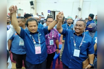 Azman (kiri) bersama Menteri Besar Kedah, Datuk Seri Muhammad Sanusi Md Nor ketika meraikan kemenangan PN di Pusat Penjumlahan Rasmi Undi Kompleks Sukan Hi-Tech Kulim Kedah pada Rabu.