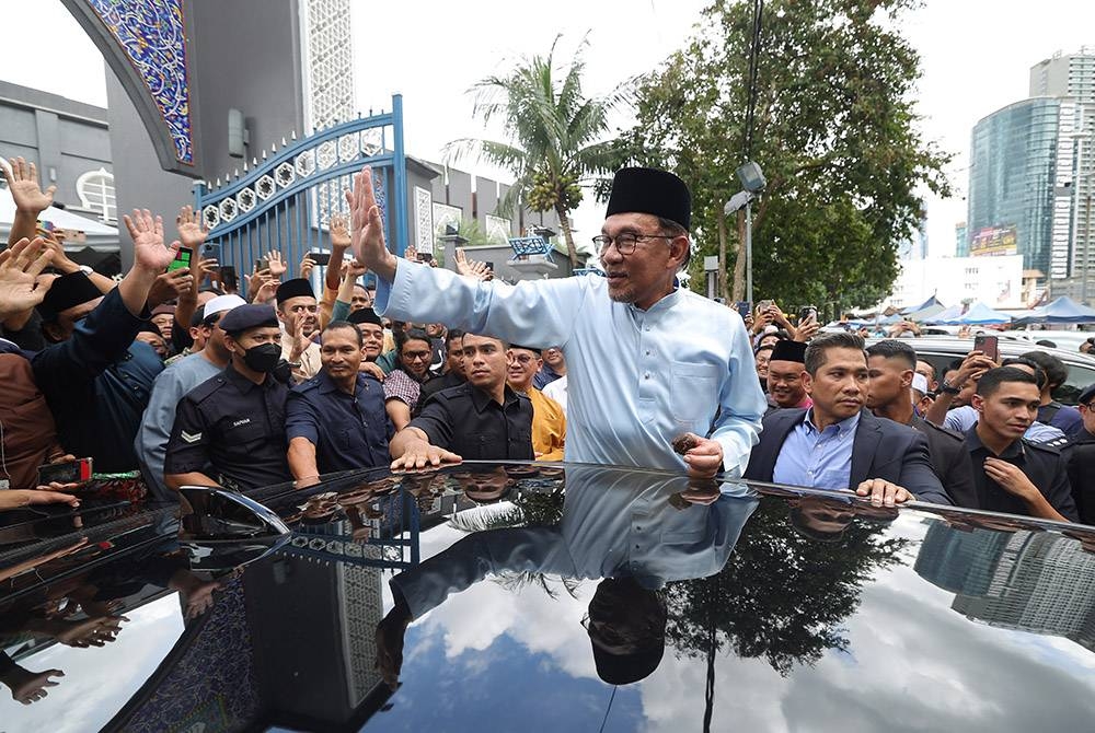Anwar meninggalkan Masjid Jamek Kampung Baru selepas menunaikan solat Jumaat di masjid tersebut pada Jumaat. Foto Bernama.