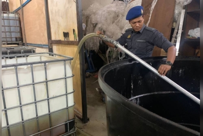 Pegawai KPDNKS melihat paip yang disambung untuk untuk memindahkan minyak masak bersubsidi ke dalam tangki. - Foto Ihsan KPDNKS