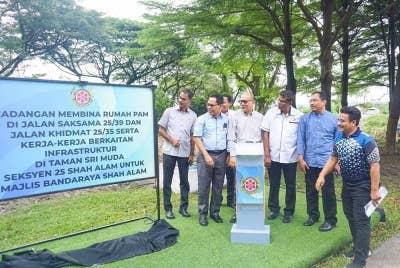 Izham (tiga dari kiri) menyempurnakan projek pecah tanah SASUD di Taman Sri Muda di sini pada Jumaat