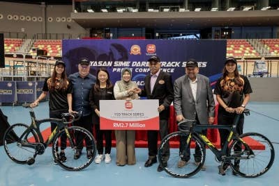 Hannah (tiga, kiri) menyaksikan penyerahan replika cek Majlis Pelancaran Kejohanan YSDTS di Velodrom Nasional pada Jumaat. - Foto Bernama