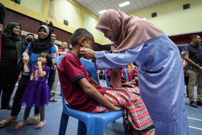 Fadhlina menenangkan adik, Mohamad Zafril Amsyar Mohd Hafiz, 8, yang akan berkhatan ketika Program Khatan Perdana Kadun Jawi 2022 pada Sabtu. - Foto Bernama