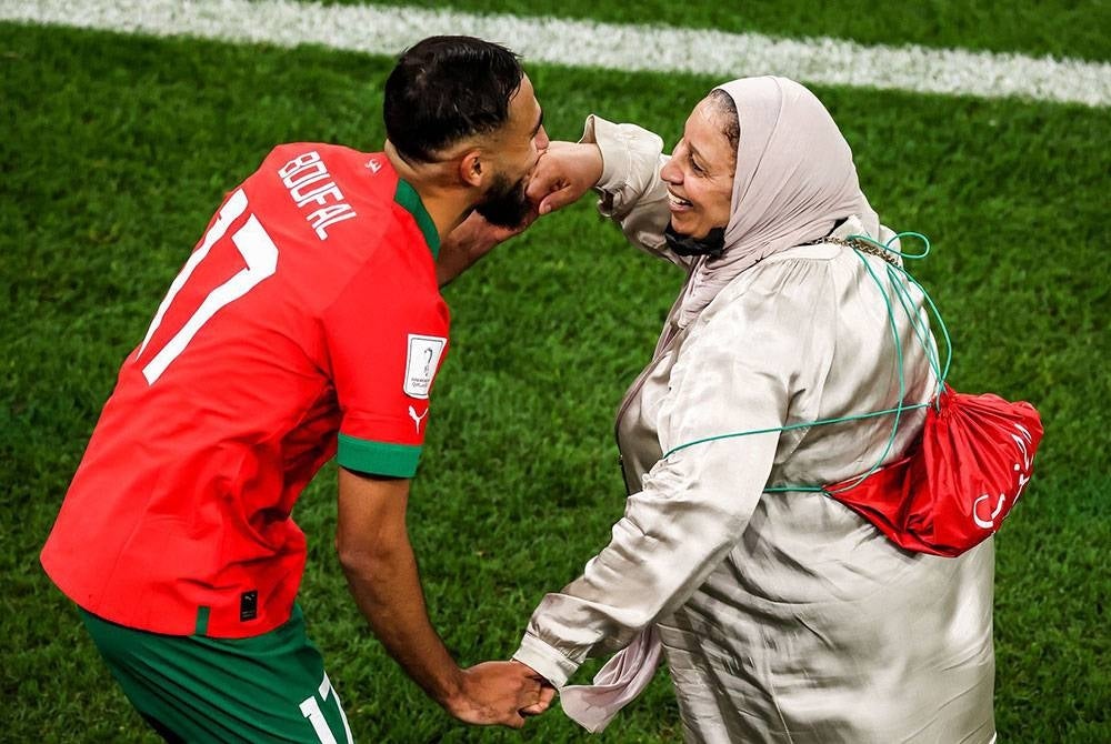 Sofiane Boufal meraikan kejayaan Maghribi mara ke separuh akhir bersama ibunya di Stadium Al Thumama.