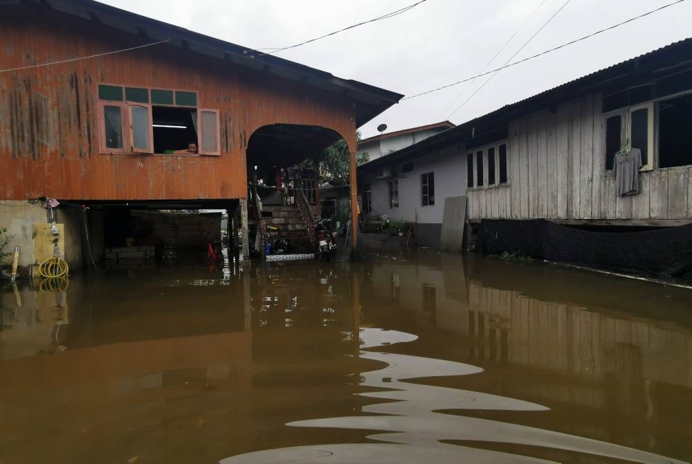 Laluan masuk ke rumah Harniza di Kampung Padang Luar, Kuala Ibai di Kuala Terengganu yang dinaiki air dan sukar surut akibat banjir termenung.