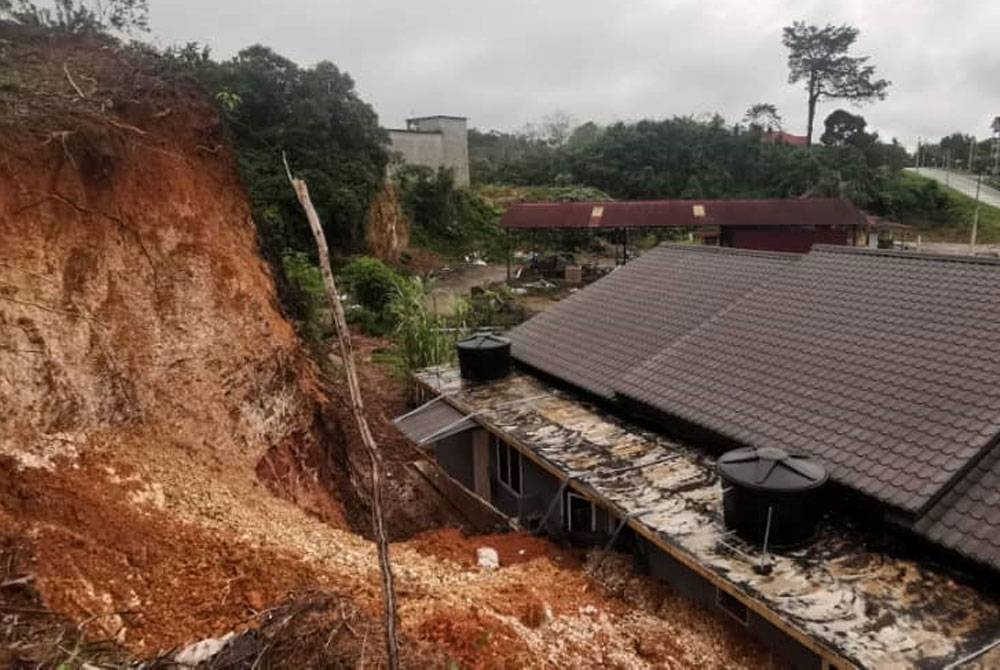 Keadaan tebing yang runtuh dan nyaris menghempap dua rumah di Kampung Mela di sini pada awal pagi Ahad.