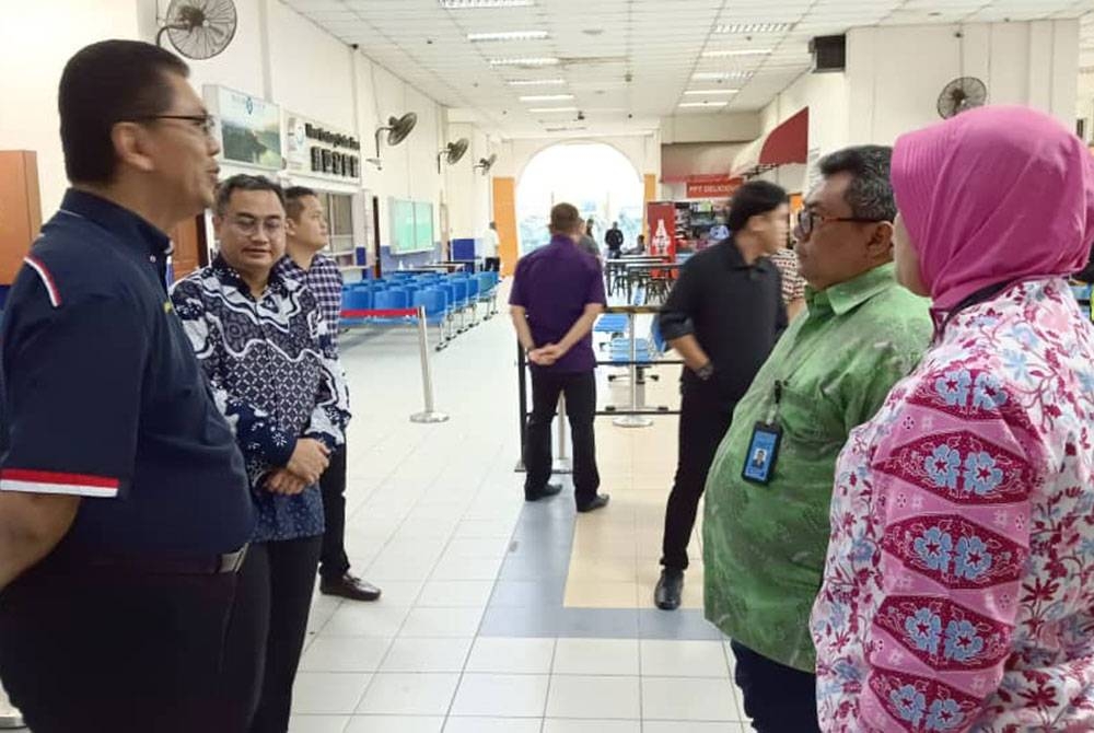 Sigit (dua dari kanan) mendengar penerangan daripada Mohd Tuah (kiri) berkenaan operasi di Terminal Feri Pasir Gudang, Pasir Gudang, pada Ahad