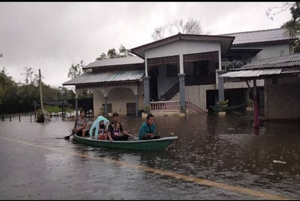 
Penduduk menggunakan perahu menyeberang banjir dari halaman rumah ke jalan raya untuk berpindah.