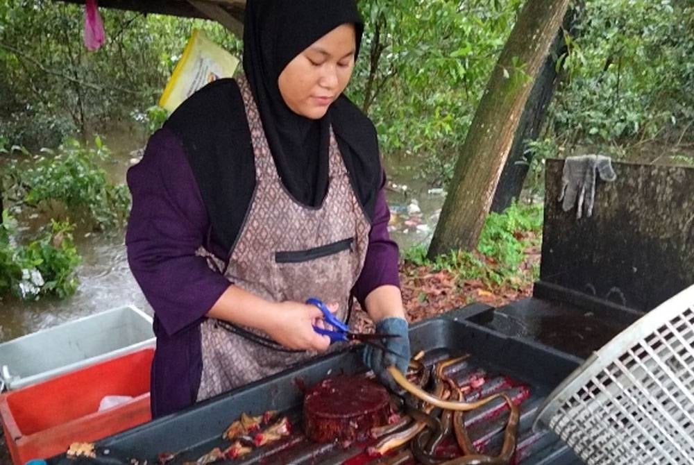 Norie Rafida menyiang belut yang ditempah pelanggan.