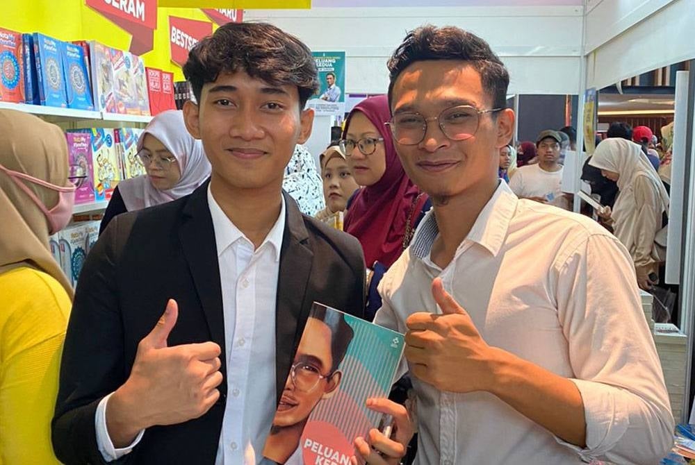 Muhammad Izzad sempat bergambar bersama pengunjung yang hadir ke Majlis Pelancaran Buku Peluang Kedua pada Ahad.