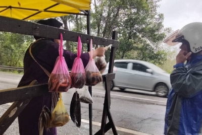 Norie Rafida menjual belut kepada pelanggan di Jalan Pasir Mas - Rantau Panjang pada Ahad.