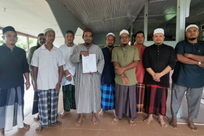 Mohd Sanizan Abd Rahman, 44, menunjukkan antara surat mahkamah berhubung proses pengambilalihan tanah di Kampung Pulau Sekati di Kuala Terengganu.