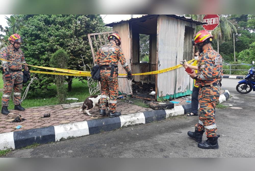 Anggota bomba sedang memeriksa sebuah pondok pengawal yang terbakar di Taman Bayam Indah, Lunas di Kulim pada malam Ahad.
