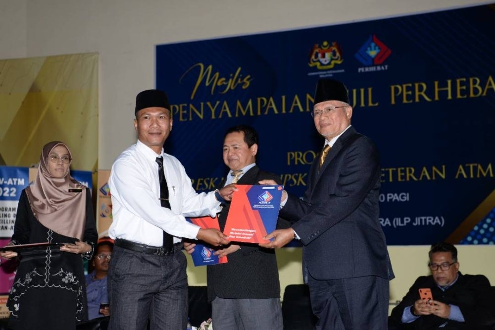 Najmi (kanan) menyampaikan sijil kepada ahli Perhebat pada Program Reskilling Upskilling Veteran ATM di Institut Latihan Perindustrian Jitra pada Isnin.