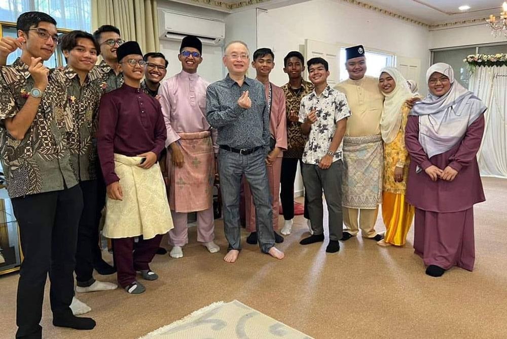 Ka Siong (berbaju kelabu) ketika hadir majlis perkahwinan sepupunya yang beragama Islam.