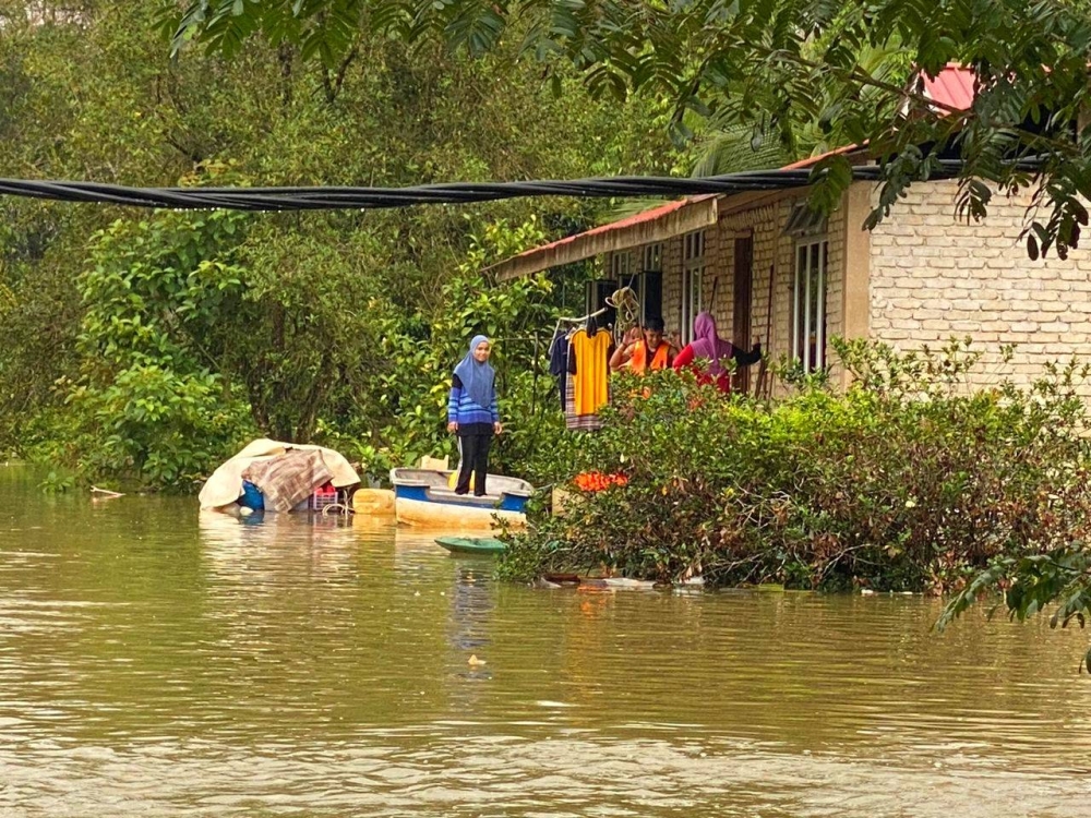 Penduduk pulang menjenguk kediaman mereka menggunakan perahu selepas berpindah ke PPS.