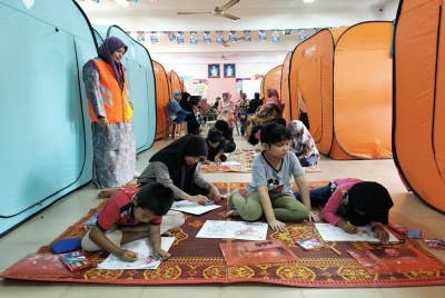 Kanak-kanak yang dipindahkan ke PPS SK Atas Tol melakukan aktiviti mewarna.