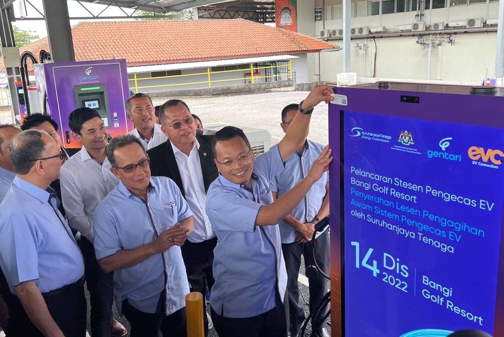 Nik Nazmi melekatkan lesen pengagihan awam sistem pengecas EV dari Suruhanjaya Tenaga pada pengecas EV Bangi Resort pada Rabu.