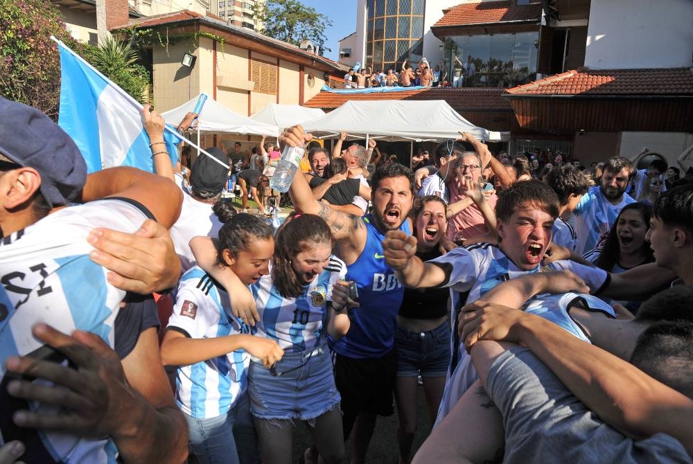Penyokong Argentina meraikan kemenangan pasukan mereka ketika menonton aksi separuh akhir Qatar 2022 di Buenos Aires. - Foto EPA