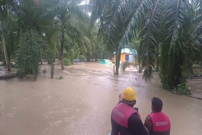 Anggota bomba membantu menyelamatkan mangsa yang terperangkap dalam banjir kilat di Kampung Muhibbah, Tanjung Serindit Kota Tinggi, pada pagi Rabu.- Foto Bomba