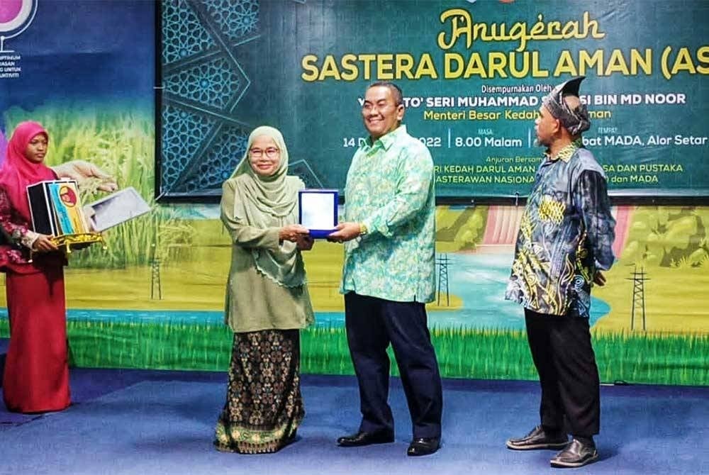 Muhammad Sanusi (kanan) menyampaikan anugerah kepada pemenang pada Majlis Anugerah Sastera Darul Aman (ASDA) pada Rabu malam.