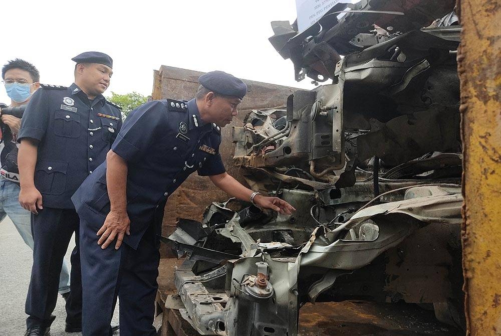 Wan Kamarul Azran (kanan) menunjukkan rangka kenderaan curi yang dirampas susulan penahanan empat suspek di sekitar Lembah Klang, baru-baru ini.