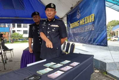 Wan Kamarul Azran menunjukkan wang tunai yang dirampas susulan serbuan sebuah rumah transit di Cyberjaya, Ahad lalu.