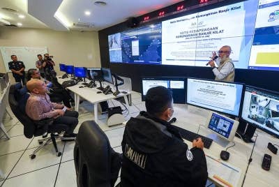 Armizan (kiri) mendengar taklimat daripada pegawai Agensi Pengurusan Bencana Negara (NADMA) di bilik kawalan kaji cuaca selepas Majlis perjumpaan dengan rakan NADMA di Markas Pasukan Mencari dan Menyelamat Khas Malaysia SMART, Pulau Meranti Puchong, pada Khamis. - Foto Bernama