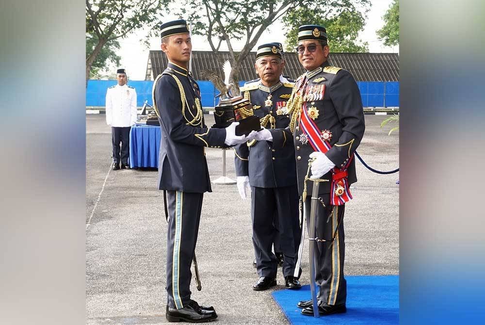 Mohd Asghar Khan (kanan) menyampaikan Piala Panglima Tentera Udara (Pelatih Terbaik Keseluruhan Sayap Kaku) dan kepada Leftenan Mubin Mustaza Iskandar (kiri) pada Upacara Perbarisan Penyampaian Sayap bagi Kursus Asas Penerbangan Siri 83/21 dan Kursus Asas Penerbangan Helikopter Siri 63/21 di Kolej Tentera Udara, di Alor Setar, pada Sabtu.