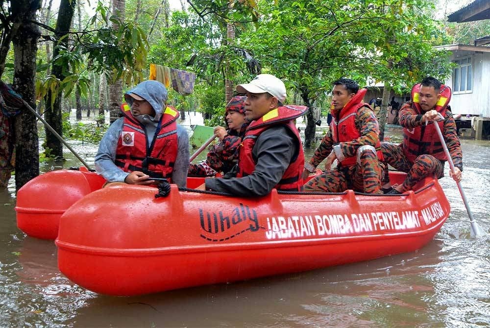 Anggota Bomba dan Penyelamat Rantau Panjang melakukan pemantauan di kawasan rumah penduduk kampung Padang Licin yang terjejas akibat bencana banjir. - Foto Bernama