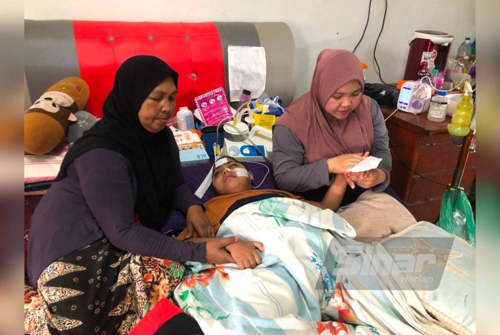 Siti Noor Mastubaidura (kanan) dan Norhayati (kiri) sentiasa berada bersama Muhammad Aiman (tengah).