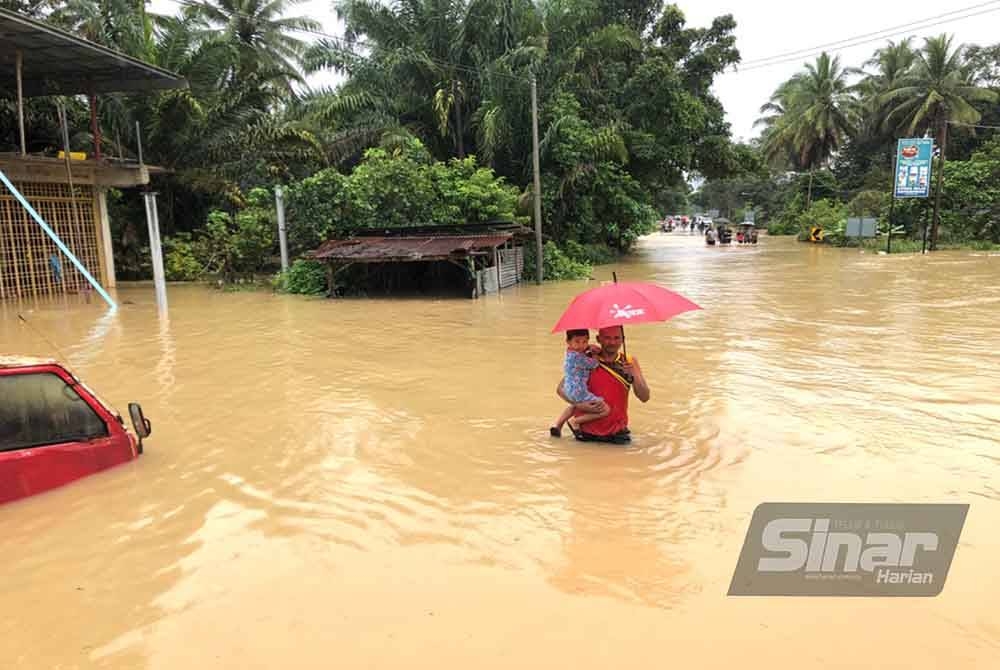 Penduduk meredah banjir bagi menyelamatkan diri sementara menunggu pasukan keselamatan tiba.