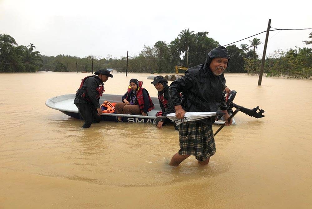 Mohamad (kanan) dan Nur Syafeqah (dua dari kiri) menaiki bot pasukan keselamatan untuk ke PPS.