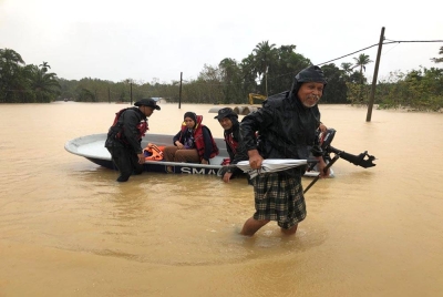 Mohamad (kanan) dan Nur Syafeqah (dua dari kiri) menaiki bot pasukan keselamatan untuk ke PPS.