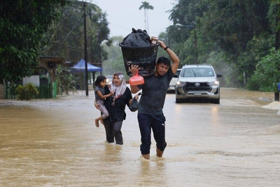 Penduduk setempat mula berpindah selepas rumah mereka dilanda banjir ekoran hujan lebat semasa tinjauan di Kampung Buluh hari ini. -Foto Bernama