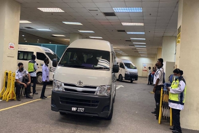 Dua van yang keluar membawa tiga jasad mangsa tanah runtuh di Batang Kali, Selangor.