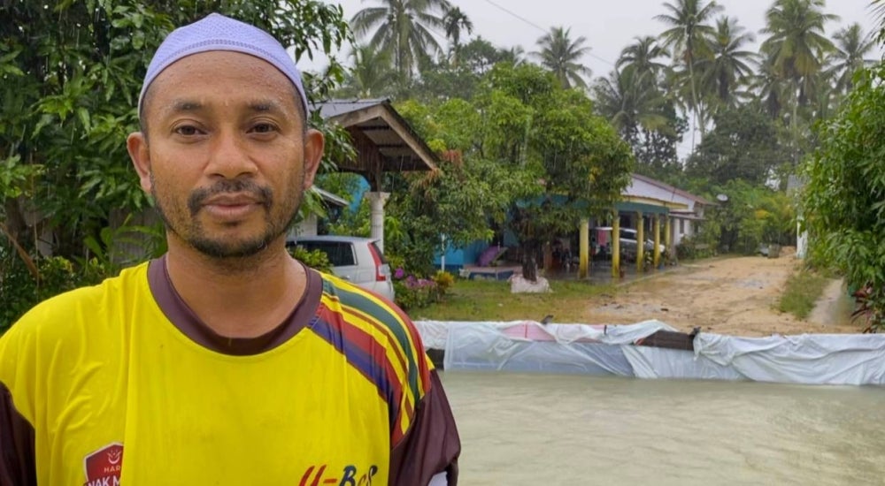 Suhaimi menunjukkan keadaan kediamannya dan keluarga yang tidak dilimpahi air selepas pemasangan benteng menggunakan plastik.