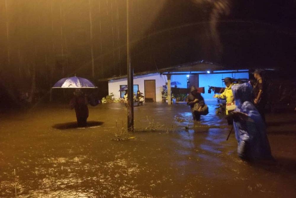Anggota bomba membantu memindahkan mangsa banjir dari kawasan terjejas di Sungai Ular di Kuantan.