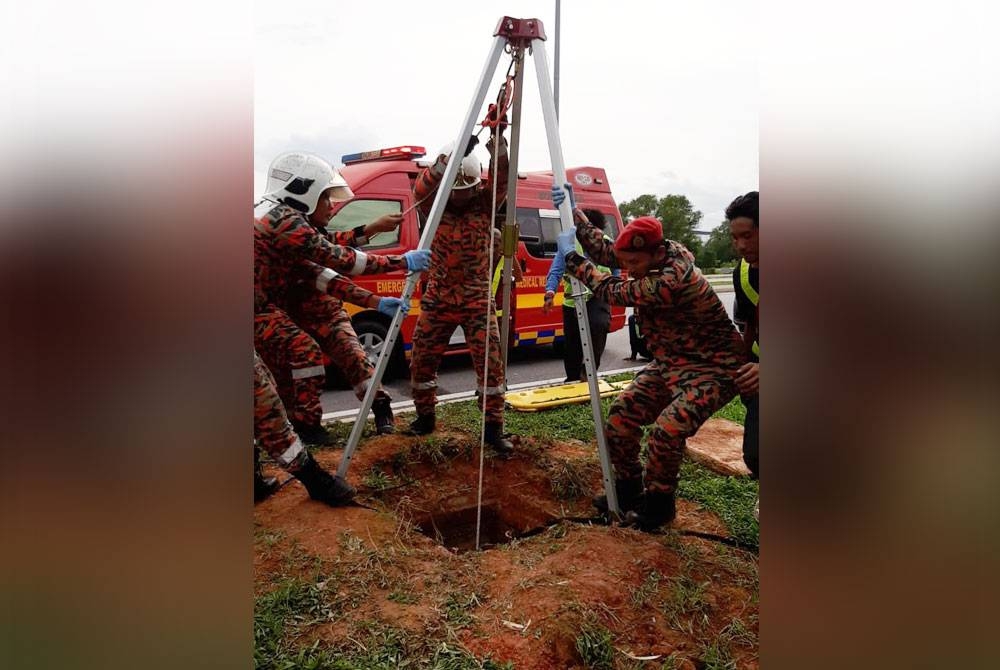 Anggota bomba sedang menjalankan kerja mengeluarkan ketiga-tiga mangsa yang maut selepas dipercayai lemas dalam saluran pembentungan di Taman Sains 2, Cyberjaya di sini pada Isnin.